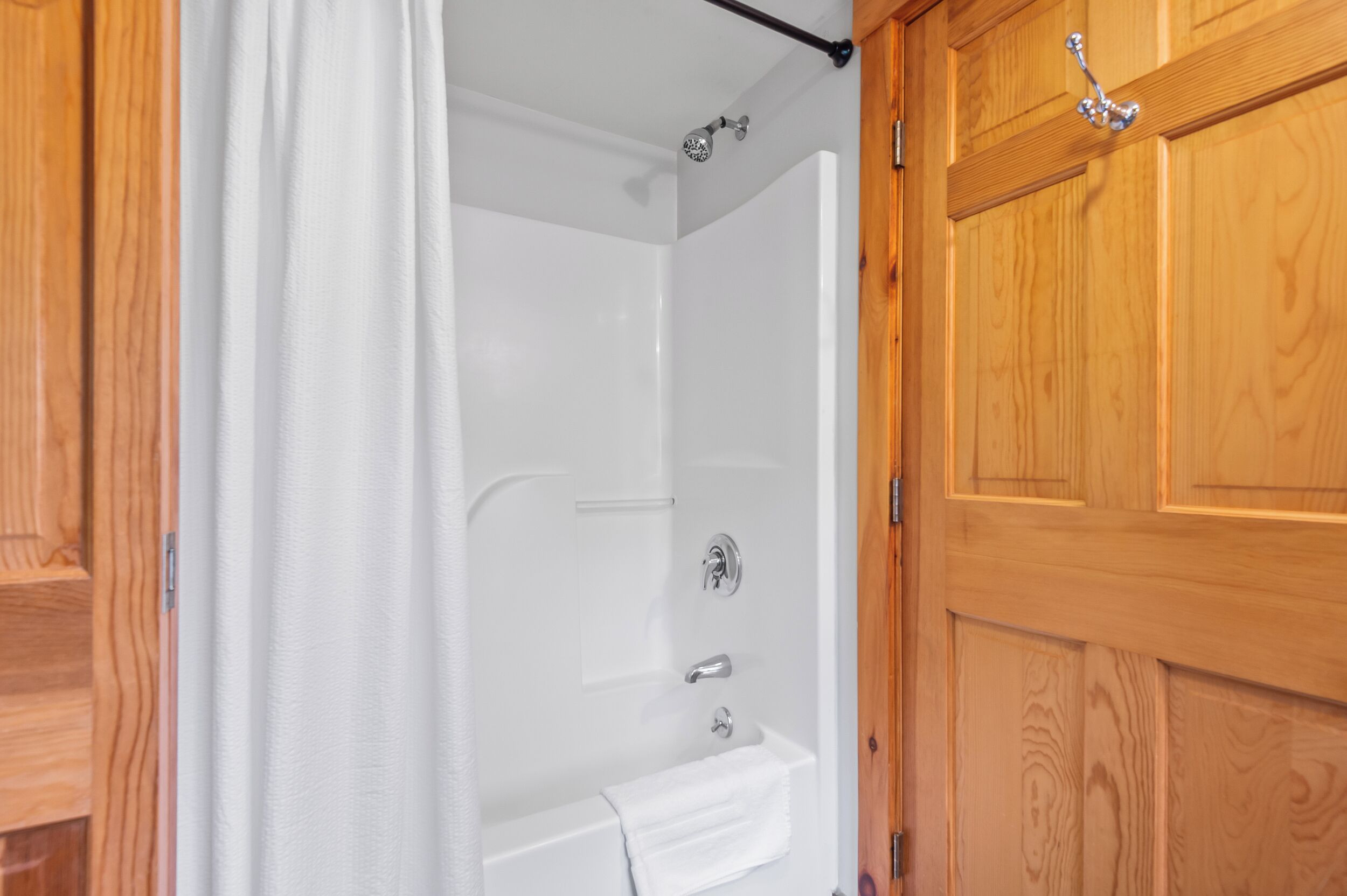 A wooden door with a towel hanging on a rack.