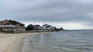 En strand med hus längs kusten.