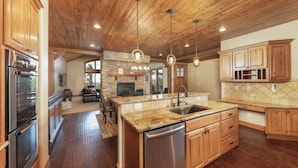 A spacious kitchen with wooden cabinets, a granite countertop, and a built-in dishwasher. - Luxury 4,200 sq ft duplex perched above Breckenridge overlooking the 10-mile range! (Breckenridge)