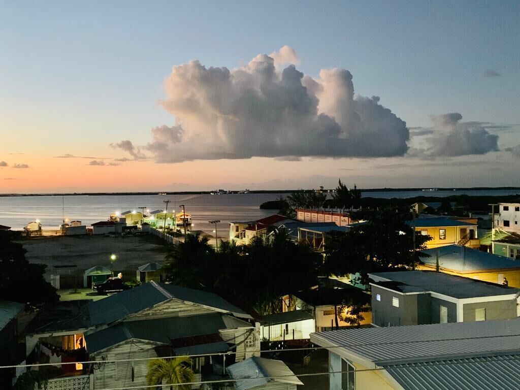 A coastal town at dusk with a large cloud formation.