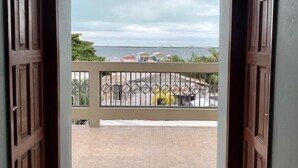 Señal de salida sobre un vano que da a un balcón con vistas a un cuerpo de agua y edificios.