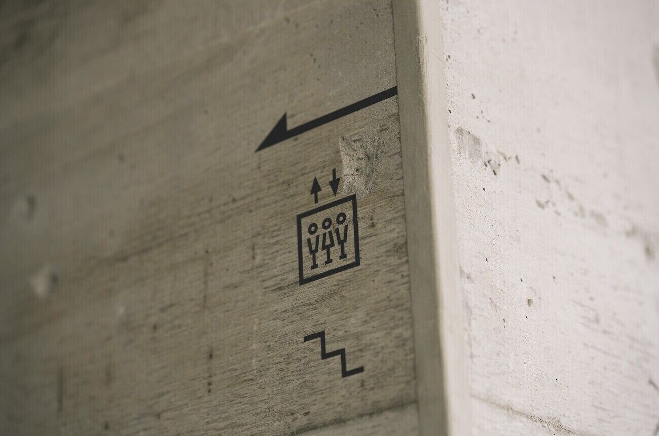 Una pared con una flecha direccional y un símbolo que indica un camino.