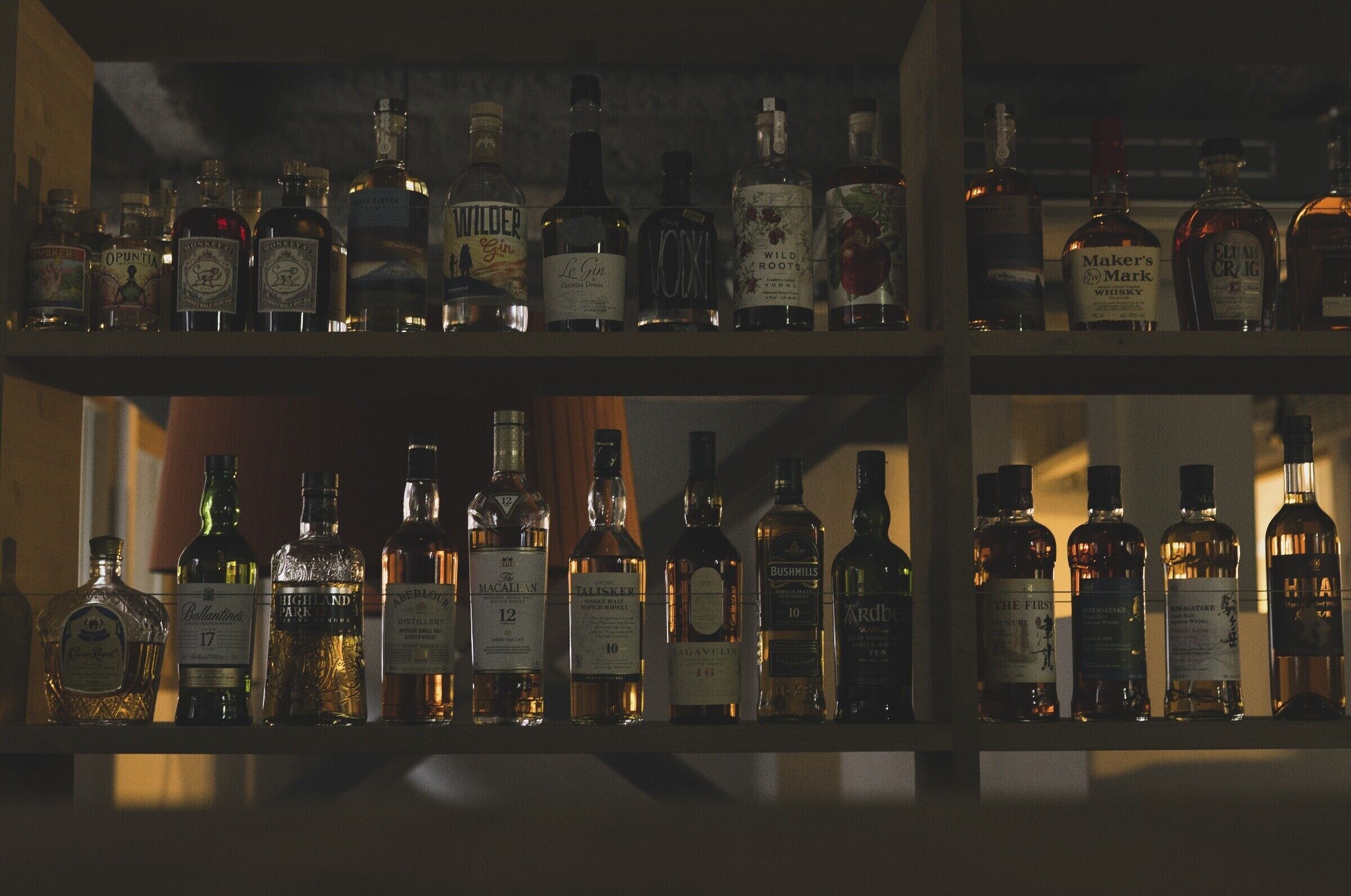 En bar med mange hylder fyldt med flasker spiritus.