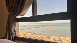 A window with a view of a beach and a pier. - My Sky • Wake to the Sea • Quiet Coastal Apartment + Private Beach (Hurghada , Al Aheya)