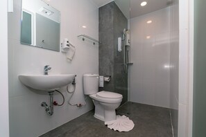 A modern bathroom with a white sink, toilet, and shower. - One Budget Chiangsaen (Chiang Saen)