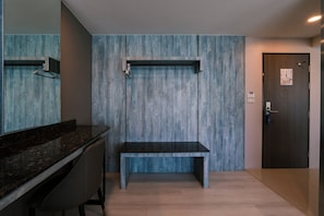 Un baño moderno con un banco, un espejo y una puerta con un letrero.