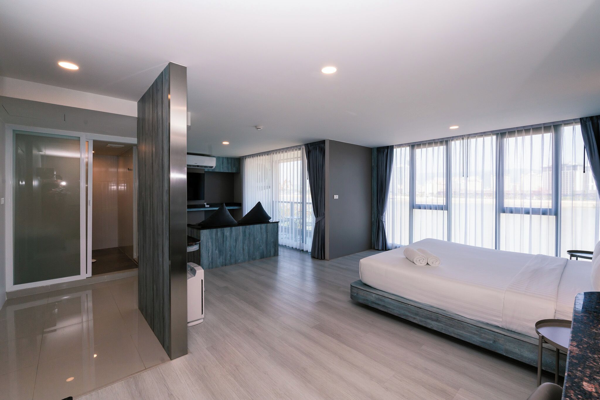 Une chambre d’hôtel moderne équipée d’un lit, d’un coin salon et d’une kitchenette.