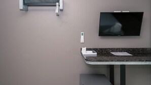 A modern bathroom with a built-in sink, a wall-mounted TV, and a towel dispenser. - One Budget Chiangsaen (Chiang Saen)