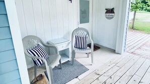 A porch with two white chairs, a small table, and a welcome sign. - Cozy little lake cottage on Buck Lake!  (Vandalia)