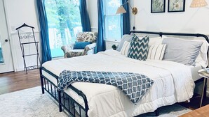 A bedroom with a bed, a ceiling fan, a chair, a lamp, and a window with curtains. - Cozy little lake cottage on Buck Lake!  (Vandalia)