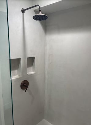 Enjoy a refreshing shower experience with a sleek glass door and convenient storage.