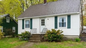 A single-story house with a front porch, a small set of steps leading to the door, and a green lawn. - Cozy home in Bangor Maine (Bangor)