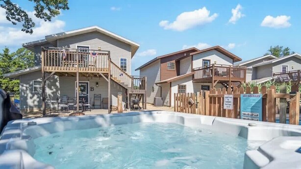 Un hôtel de style résidentiel doté d’une piscine, de balcons en bois et d’un panneau indiquant les règles d’utilisation du jacuzzi.