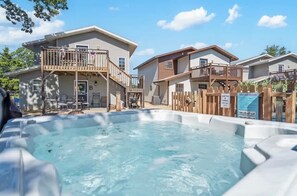 Un hôtel de style résidentiel doté d’une piscine, de balcons en bois et d’un panneau indiquant les règles d’utilisation du jacuzzi.