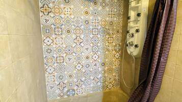 Ducha con pared de azulejos que presenta un diseño geométrico.
