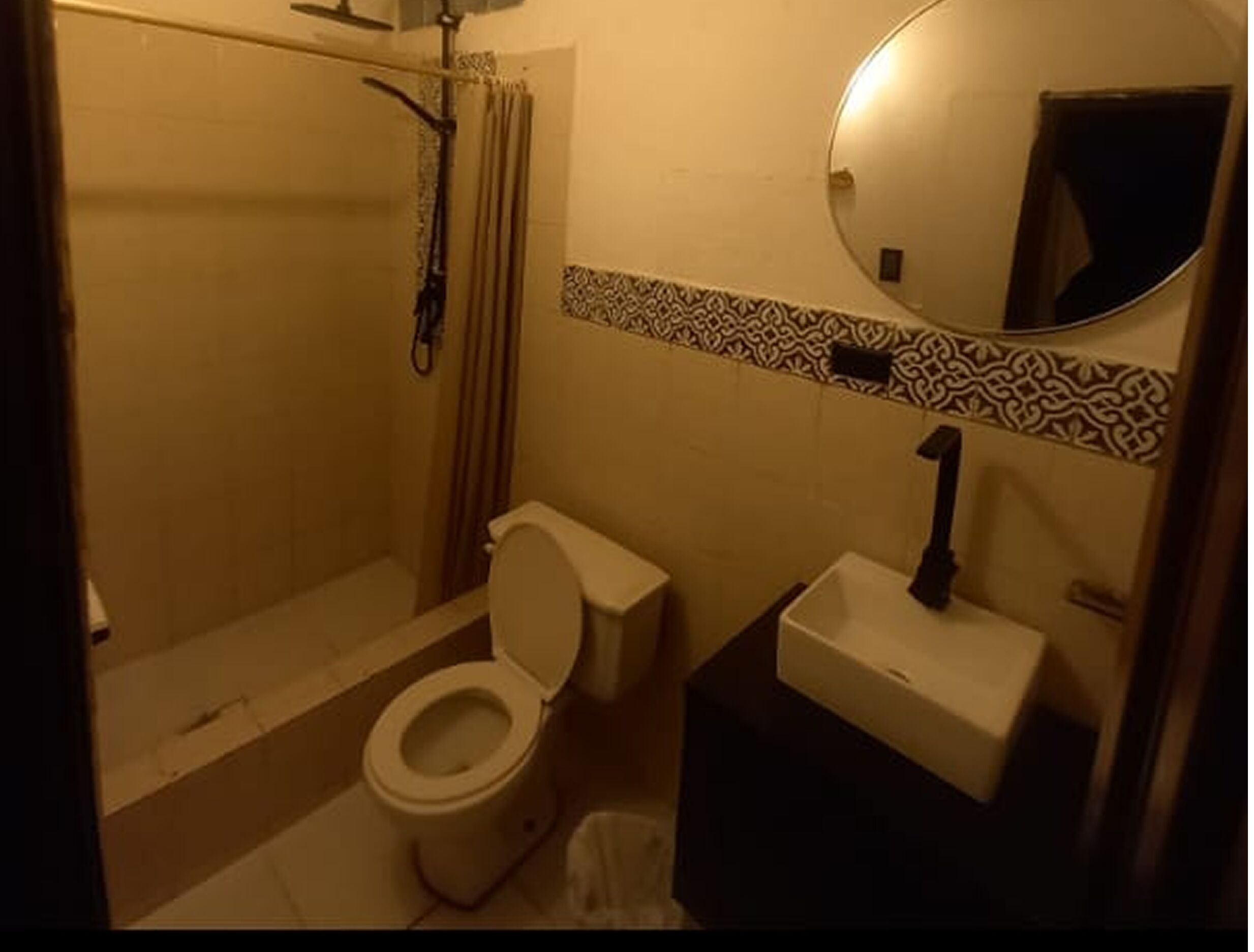 A bathroom with a toilet, sink, and shower.