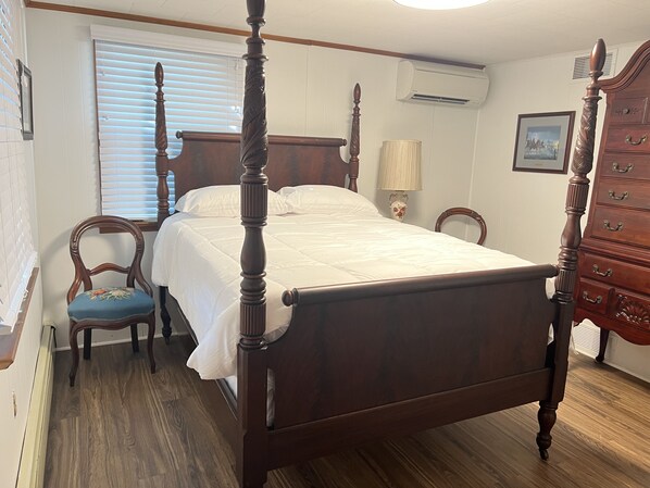 A four-poster bed with a wooden headboard and footboard, a wooden dresser with drawers, a chair with floral upholstery, and a window with blinds. - Gettysburg Carriage House 252 Baltimore Street Rear House ~Entire House Rental!  (Gettysburg)