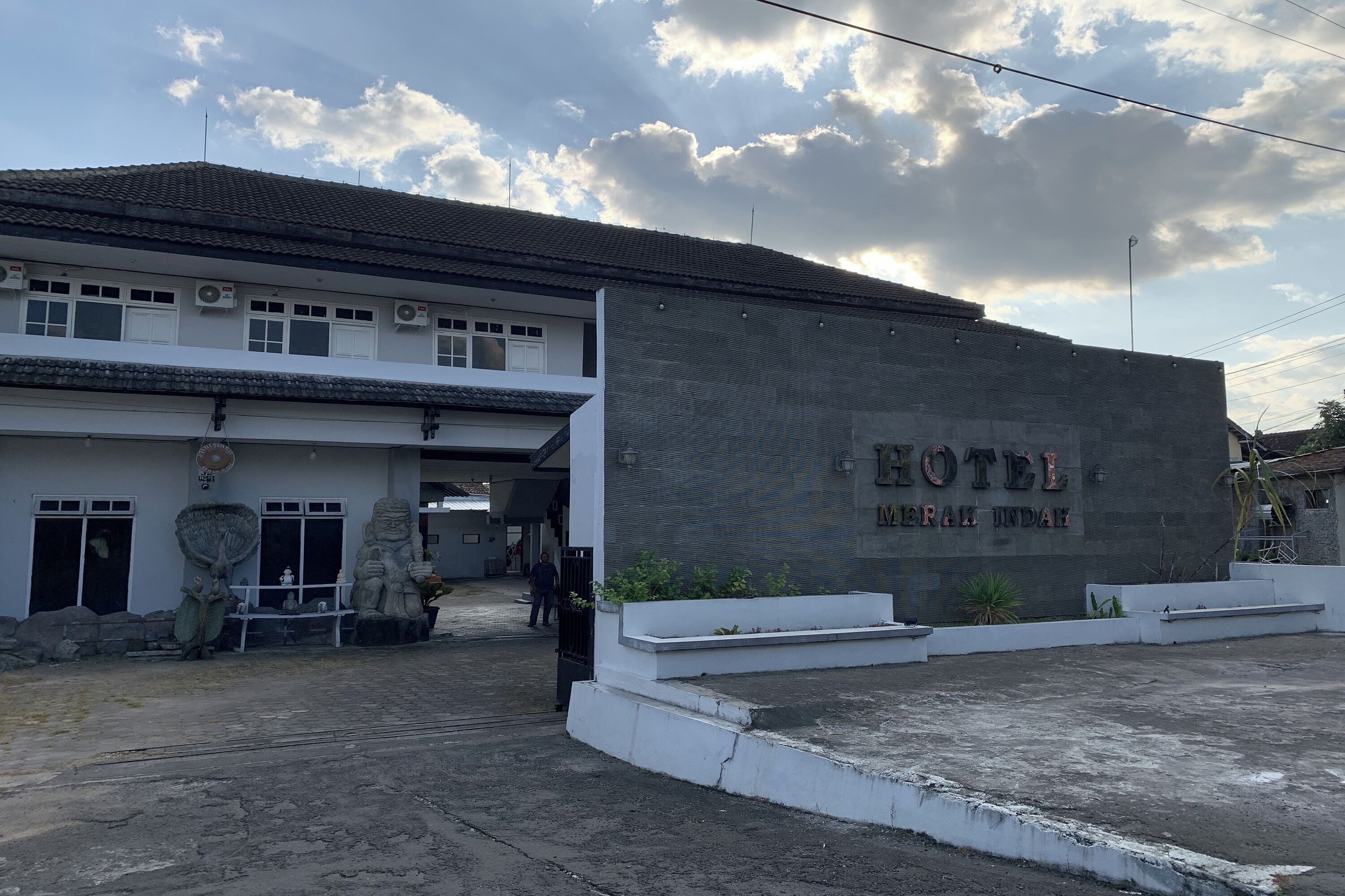A building with a sign that reads "HOTEL DESA INDAH."