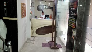 A reception desk with a person seated behind it, a clock on the wall, and a poster advertising tours and travels. - Hotel AV International Near New Delhi Railway Station, Paharganj (New Delhi)