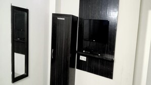 A room with a black wardrobe, a mirror, and a mounted television. - Hotel AV International Near New Delhi Railway Station, Paharganj (New Delhi)