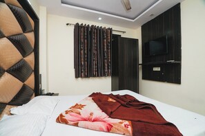 A hotel room with a bed, a TV mounted on the wall, and a window with curtains. - Hotel AV International Near New Delhi Railway Station, Paharganj (New Delhi)