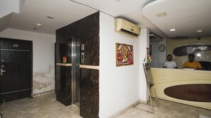 A reception area with a marble column, a clock, and a wall-mounted air conditioner. - Hotel AV International Near New Delhi Railway Station, Paharganj (New Delhi)