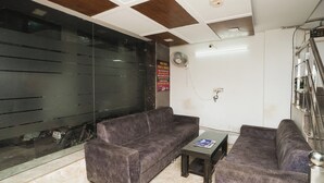 A reception area with a sofa, a small table, and a glass partition. - Hotel AV International Near New Delhi Railway Station, Paharganj (New Delhi)