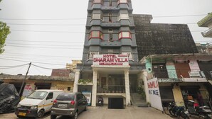 Un edificio de varios pisos con un letrero que indica Hotel Dharamvilla.