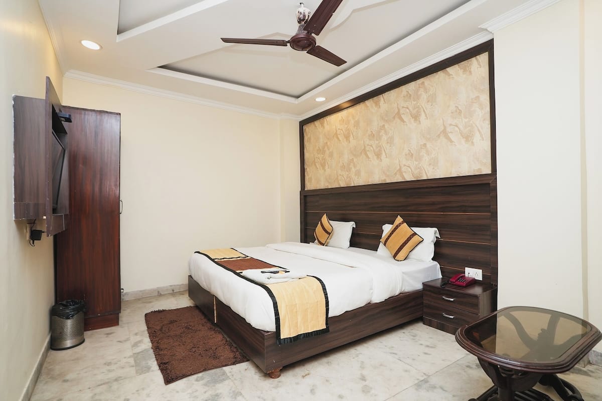 Un dormitorio con cama, mesita de noche y ventilador de techo.