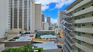 A high-rise building with multiple floors, a parking lot, and a staircase leading to an upper level.