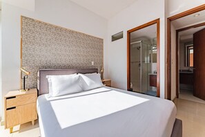 A modern hotel room with a large bed, wooden nightstands, a patterned headboard, and a walk-in closet. - VH | Depa 2 hab + wifi | Anáhuac | 154 (Ciudad de México)