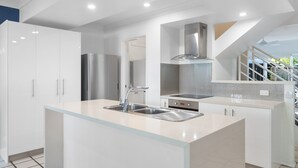 Una cocina moderna con una isla central, electrodomésticos de acero inoxidable y un diseño elegante.