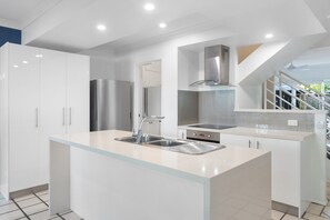 Enjoy cooking in this well-lit kitchen with a central island, oven, and stainless steel appliances.