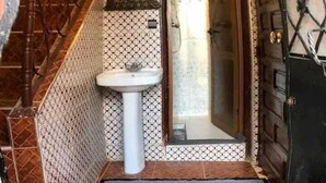 A narrow hallway with a white sink, a wooden staircase, and a door with a diamond-patterned design. - Wohnung in Safi  (Safi)