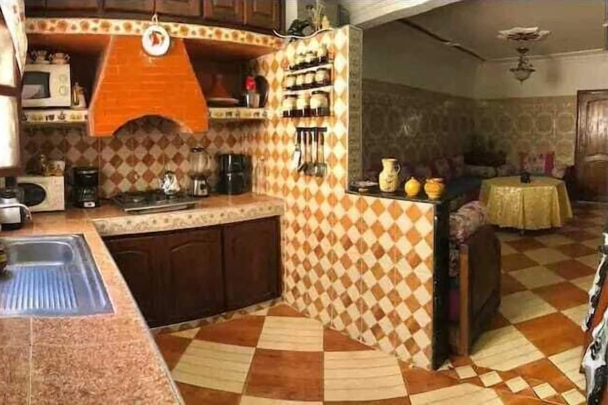 A kitchen with a checkered floor, a sink, and a stove.