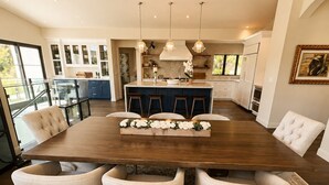 A spacious dining area with a large wooden table, four upholstered chairs, and a decorative centerpiece.