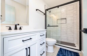 A modern bathroom with a white vanity, a glass shower enclosure, and a white toilet. - Private Island! Includes 2 houses, covered boathouse, best sunset on Indian Lake (Washington Township)