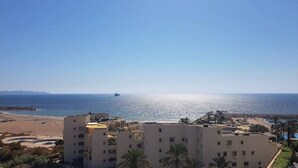 Une vue sur la côte, avec des bâtiments, une plage et une jetée.