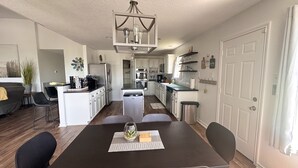 A modern kitchen with white cabinets, stainless steel appliances, and a central island. - Cozy Beach House - short walk to the water, quiet neighborhood. (Galveston)
