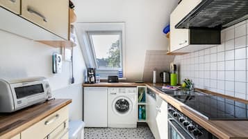 Una cocina compacta equipada con lavadora, tostadora y estufa.