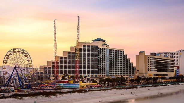 A coastal hotel with a large Ferris wheel and a beach in the foreground. - Unleash the Fun: Pool Table, Fishing Poles, and Ping Pong Table, Smoker (Port Orange)