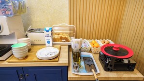 A kitchen counter with various items including a toaster, bowls, plates, a bottle of oil, a spatula, and a rice cooker. - Browndot Angang (Gyeongju)