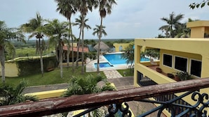 A resort with a pool, palm trees, and a view of the ocean. - Hacienda Girasoles Tampico (Pueblo Viejo)