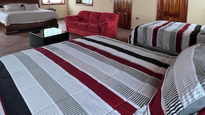 A room with a large bed, a red sofa, and two doors. - Hacienda Girasoles Tampico (Pueblo Viejo)