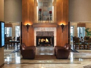 A lobby with a fireplace, leather armchairs, and a dining area. - Always a Great Idea To Unwind! Close to Portalis Office Park, w/ Outdoor Pool! (Scottsdale)
