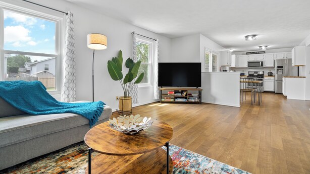 En moderne stue med sofa, sofabord og fjernsyn.