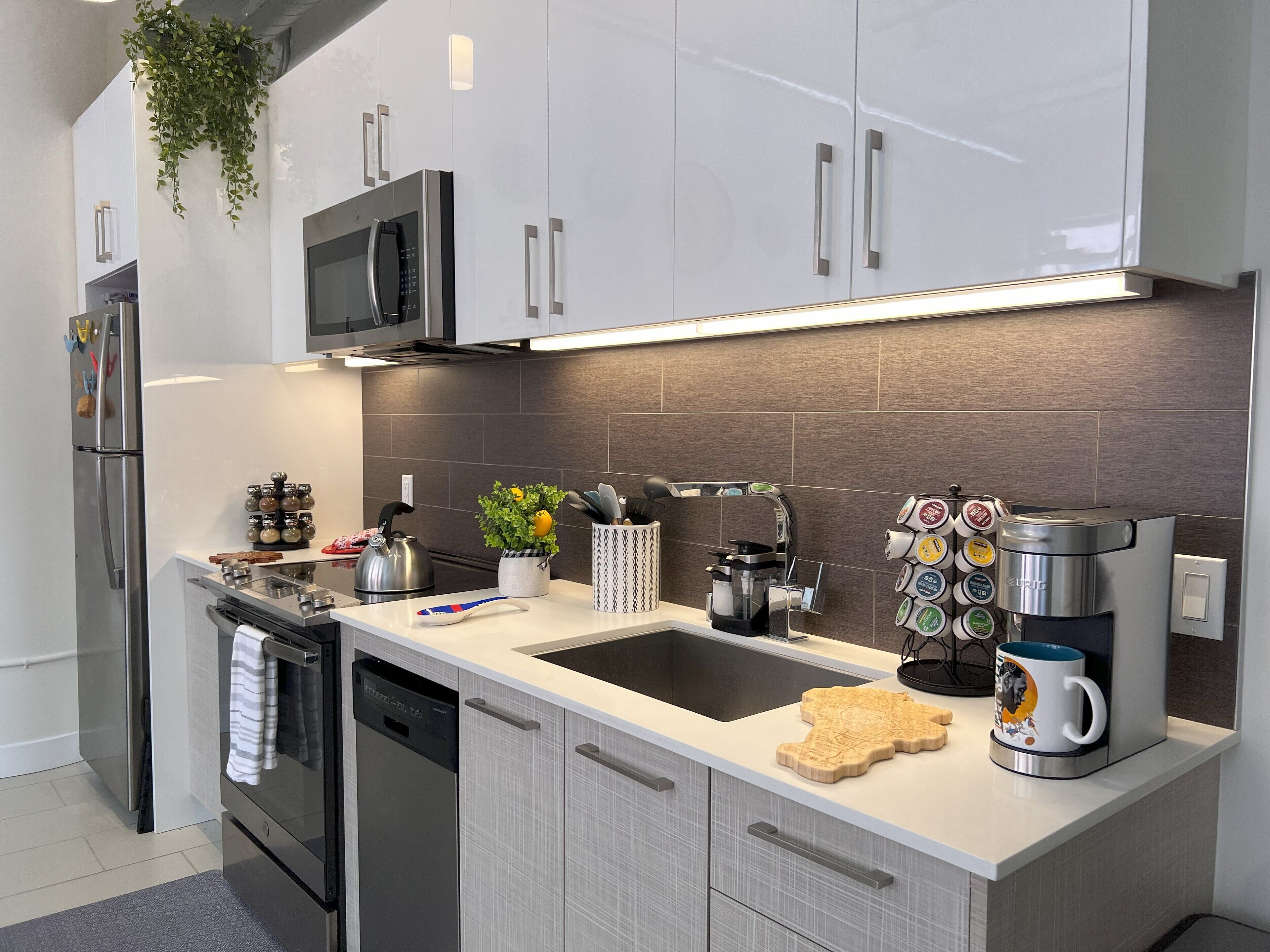 Eine moderne Küche mit Edelstahlgeräten, einer eingebauten Mikrowelle und einer Kaffeemaschine.