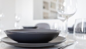 A dining table with a dark bowl and plate set for a meal.