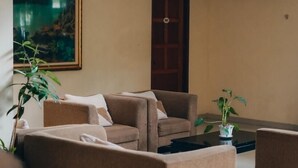 A modern living room with beige sofas, a coffee table, and a painting on the wall. - Jalan Bagindo Aziz Chan (Saringan)