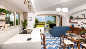 A modern interior with a kitchen, dining area, and living room. - Sea View exclusive villa with private garden and pool (Forio)